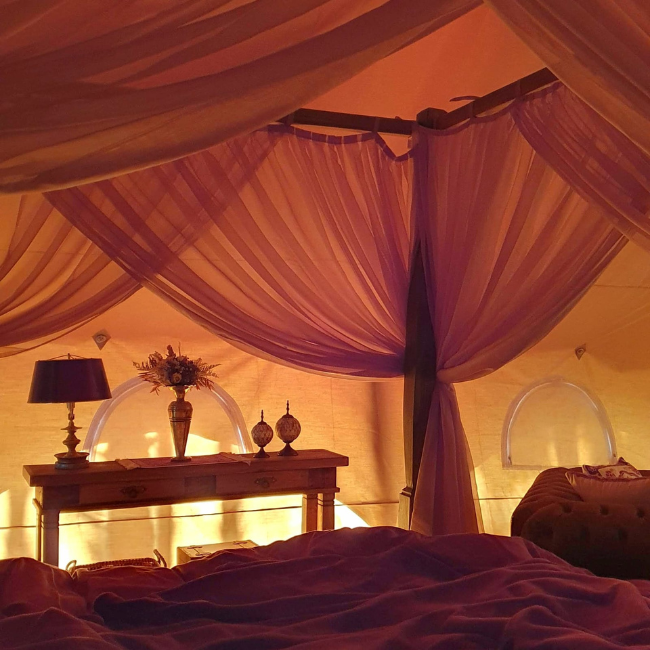 Cama king size com aquecimento e massagem no interior da tenda glamping Guardião da Montanha